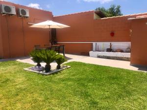 patio ze stołem i parasolem na dziedzińcu w obiekcie Apartamento con Piscina ADULTS ONLY w mieście Chiclana de la Frontera