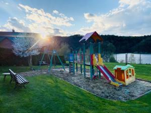 a park with a playground with a slide and a bench at Dzika Cisza DOMEK CAŁOROCZNY in Olchowiec