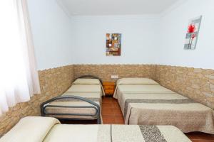 a row of beds in a room with a wall at Matilde&Leire in Barbate +12 photos