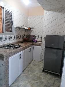 a kitchen with a stove and a refrigerator at La Perle in Meknès