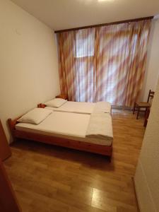 a bed in a room with a large window at Prenociste Cazin in Cazin