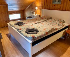 a large bed in a room with a wooden wall at Lya med utsikt in Henån