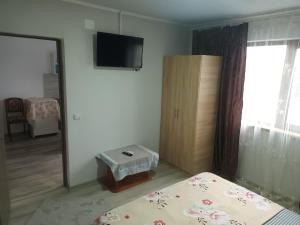 une chambre avec un lit, une télévision et un miroir dans l'établissement Cazare Corbu, à Corbu 3 autres photos