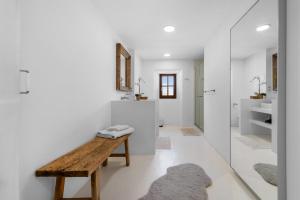 a bathroom with white walls and a wooden bench at Finca Especial El Pino Mallorca en Esporles in Esporles +72 photos