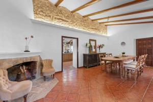 a living room with a fireplace and a table and chairs at Finca Especial El Pino Mallorca en Esporles in Esporles