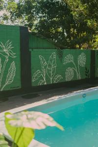 a person pointing at a wall with plants painted on it at Benteveo hostel iguazu in Puerto Iguazú +28 photos