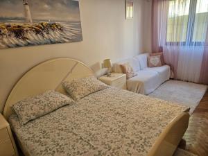 a bedroom with a bed and a living room with a couch at Apartments Cavar in Rab
