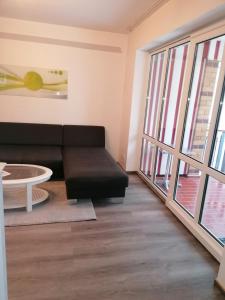 een woonkamer met een zwarte bank en een tafel bij Ostseetraum in Ostseebad Koserow