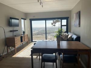 a living room with a table and chairs and a television at Nivica 54 Luxury Apartment in Langebaan