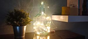 a bottle with lights next to a vase with a plant at Casa curro in Baena +11 photos