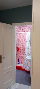 a bathroom with a red and white shower and a sink at Casa curro in Baena