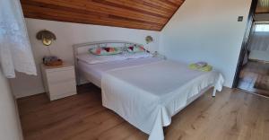 a bedroom with two beds and a wooden ceiling at ANCIENT HOUSE in Vonyarcvashegy