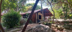 a small wooden house in the woods with trees at Pousada com chalés na serra da Meruoca in Meruoca