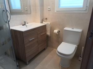 a bathroom with a toilet and a sink and a window at Apartamento Tres Ce in Alcossebre