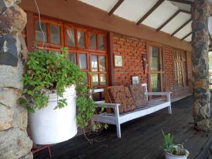 een veranda met een bankje en wat planten erop bij Eco Farm in Karatu