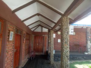 een portiek van een bakstenen gebouw met kolommen en een plafond bij Eco Farm in Karatu