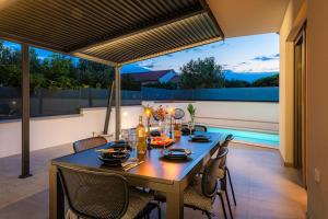 a dining table and chairs on a patio at Holiday home Val in Šibenik