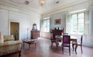 a living room with a table and a couch at Usage exclusif - Palazzo du XVI avec piscine in Crespina