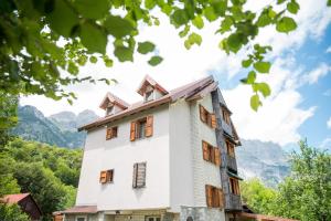 a house with mountains in the background at Villa Molla in Theth
