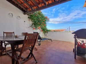 a patio with a table and chairs and a plant at Casa do Terraço by Madrabica in Atouguia da Baleia