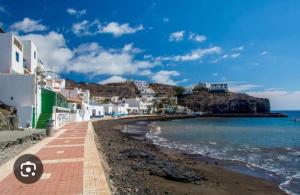 a beach with white buildings and the ocean at Roque in Las Playitas
