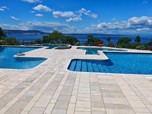 a large swimming pool with a tile floor and anergynergynergynergyploadpload at Mobile home Sparkle TT in Klenovica