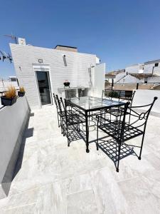 a glass table and chairs on a patio at Casa Mar y Montaña in Paterna de Rivera
