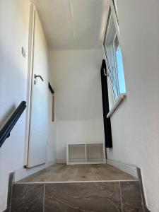 an empty hallway with a door and a window at TingsAppart - Poggenmoor in Neustadt am Rübenberge