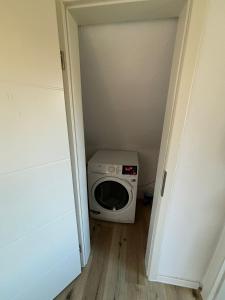 a washing machine in a room with a door open at TingsAppart - Poggenmoor in Neustadt am Rübenberge +11 photos