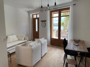 a living room with white furniture and a table at La Batellerie, vue sur Rhône in Tain-lʼHermitage