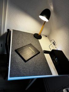 a desk with a lamp on top of a table at TingsAppart - Poggenmoor in Neustadt am Rübenberge