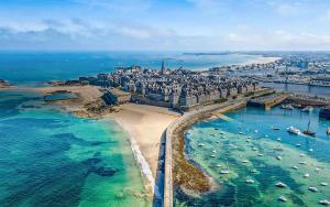 une vue aérienne d'une plage avec des bateaux dans l'eau dans l'établissement Duplex hypercentre, à Dinard