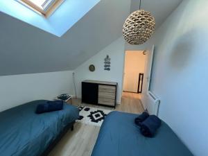 une chambre mansardée avec deux lits et un lustre dans l'établissement Duplex hypercentre, à Dinard