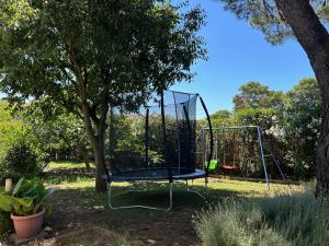 a swing in a park with a tree at Holiday Home Villa Romantica in Sveti Filip i Jakov