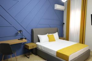 une chambre avec un lit et un mur bleu dans l'établissement City Center Rooms Durres, à Durrës