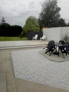 Un patio con una mesa y sillas y una mesa. en Gite les sapins, en Friville-Escarbotin