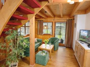 フロイデンシュタットにあるKienberg - Landhaus Anjaの緑の家具と木製の天井が備わるリビングルーム