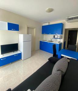 a living room with blue cabinets and a white refrigerator at Irina Apartments in Ravda