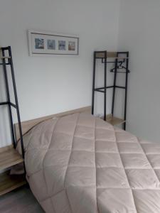 Una habitación con una cama grande con dos estantes. en Gite les sapins, en Friville-Escarbotin
