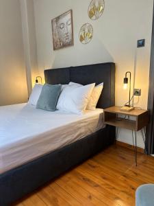 a bedroom with a large bed with a night stand at KONAR Guest House in Alexandroupoli