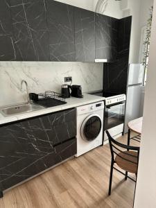 a kitchen with a sink and a washing machine at KONAR Guest House in Alexandroupoli