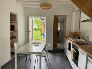 オービニー・シュル・ネールにあるPetite maison Duplexのキッチン(白いテーブル、椅子付)