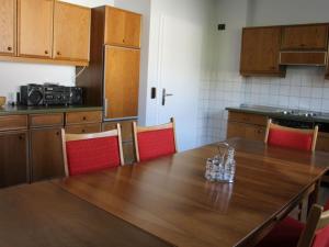 a kitchen with a wooden table and red chairs at Miss Comfortable Holiday Residence in Bad Berleburg +16 photos