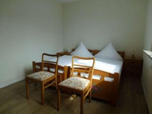 a bedroom with a bed and two chairs at Miss Comfortable Holiday Residence in Bad Berleburg