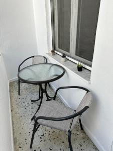 a glass table and a chair in a window at KONAR Guest House in Alexandroupoli