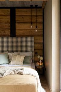 a bedroom with a bed with a wooden wall at apartamenty 1006 m n p m in Bustryk