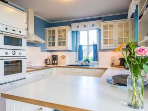a kitchen with white cabinets and a vase of flowers at Blue Wonder Comfortable holiday residence in Zinnowitz