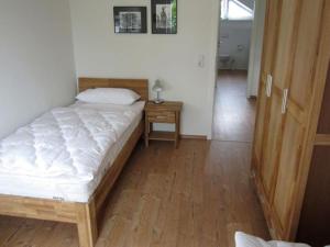 een slaapkamer met een bed en een nachtkastje met een tafel bij House Saga - Huus Asgard in Nieby