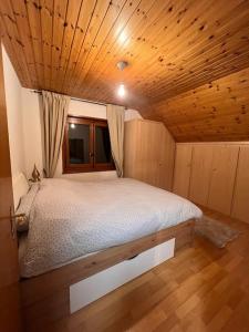 PullyにあるAppartement spacieux à Lausanneの木製の天井の客室のベッド1台分です。