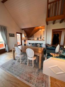 PullyにあるAppartement spacieux à Lausanneの木製のテーブルと椅子のあるリビングルーム